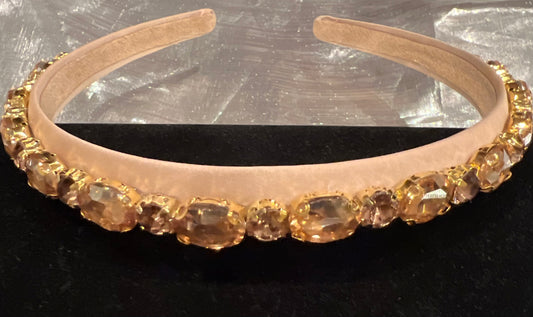 Beige headband with gold rhinestones.