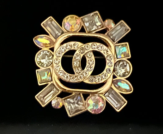 Gold tone geometric stone and rhinestone double o brooch.