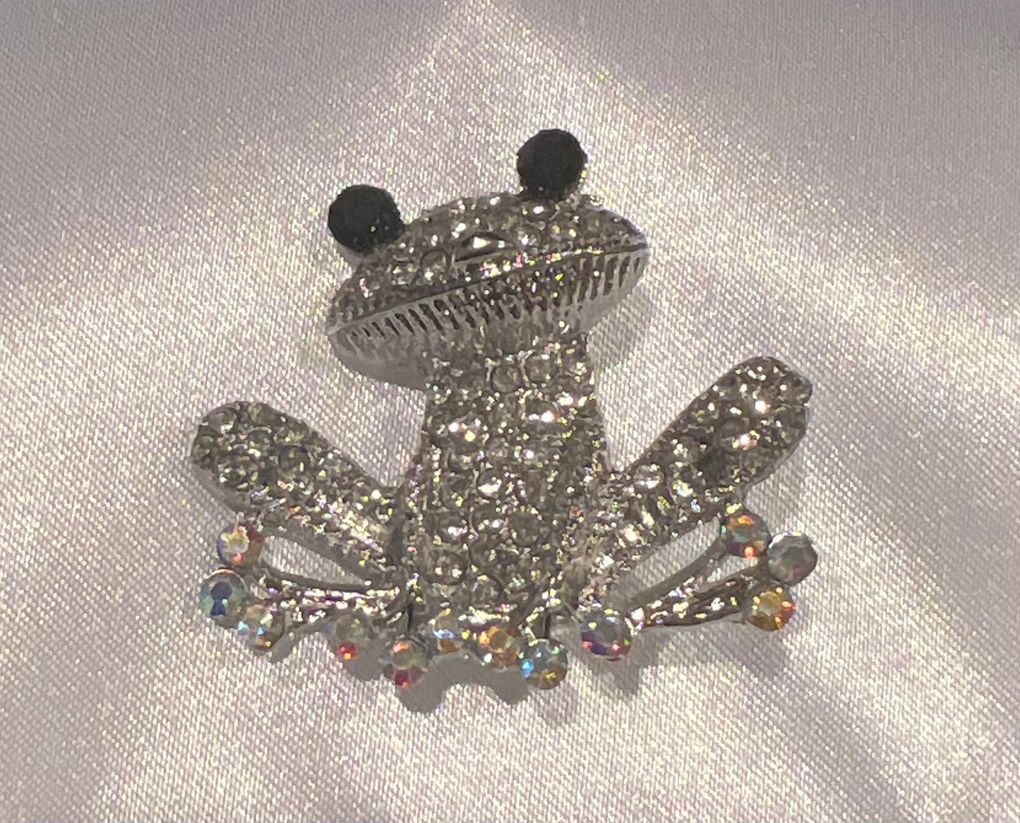 Silver tone frog with rhinestones.