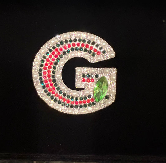 G brooch with pearls and red and green rhinestones with emerald green stone.